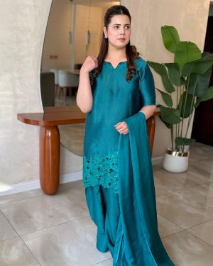 This elegant green ensemble showcases a beautifully tailored short shirt paired with a traditional Farshi shalwar, creating a graceful and sophisticated look. Made from smooth medium silk fabric.